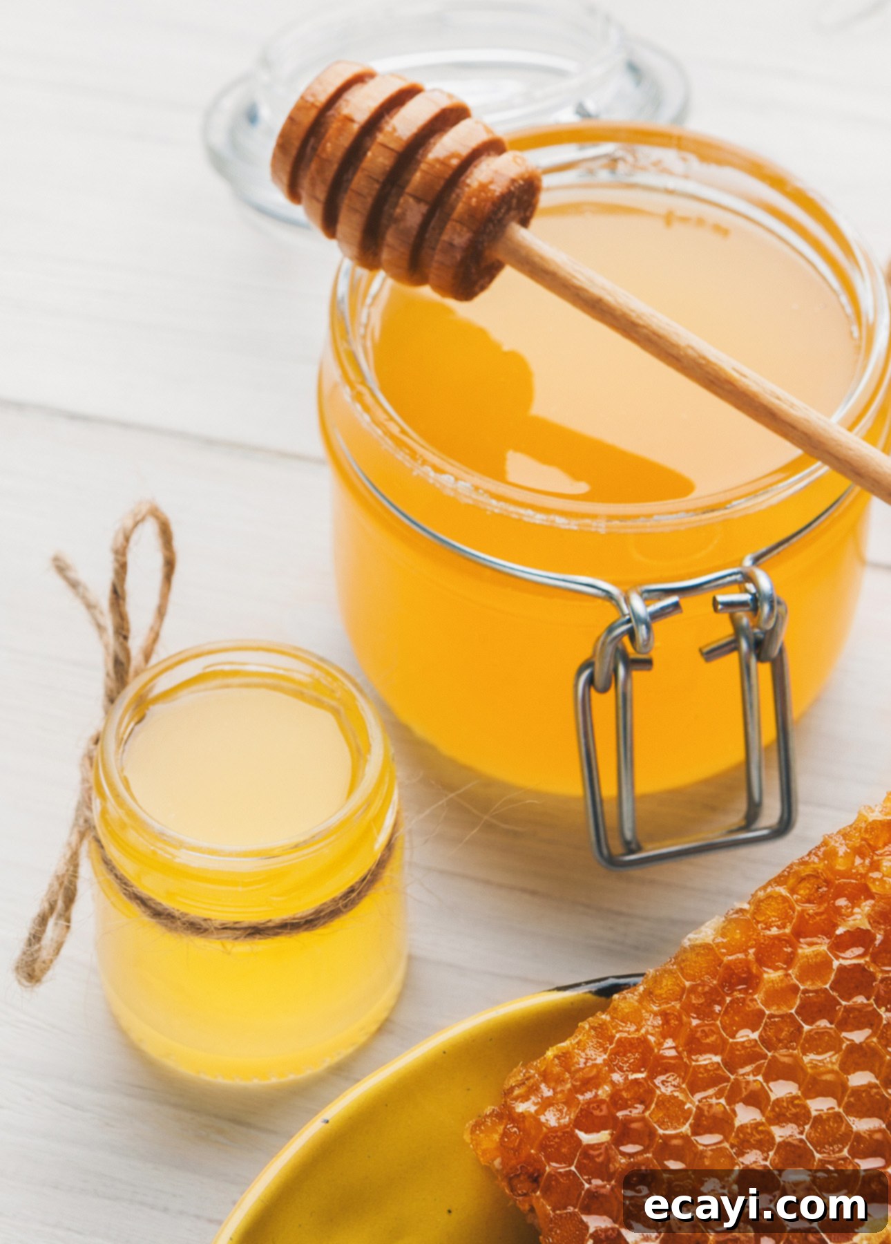 Luscious Honey Orange French Macarons 4 Assortment of different honey jars, a bowl of honey, and a piece of honeycomb on a wooden surface