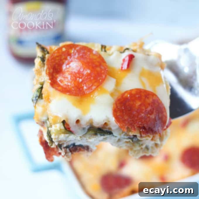 Pizzagna 5 A close up of a perfect slice of pizza lasagna on a spatula, ready to be served.
