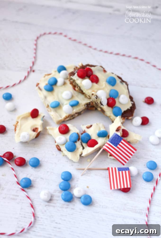 Stars and Stripes Candy Bark 3 An overhead photo of patriotic candy bark with red white and blue M&Ms and American flags in the background.