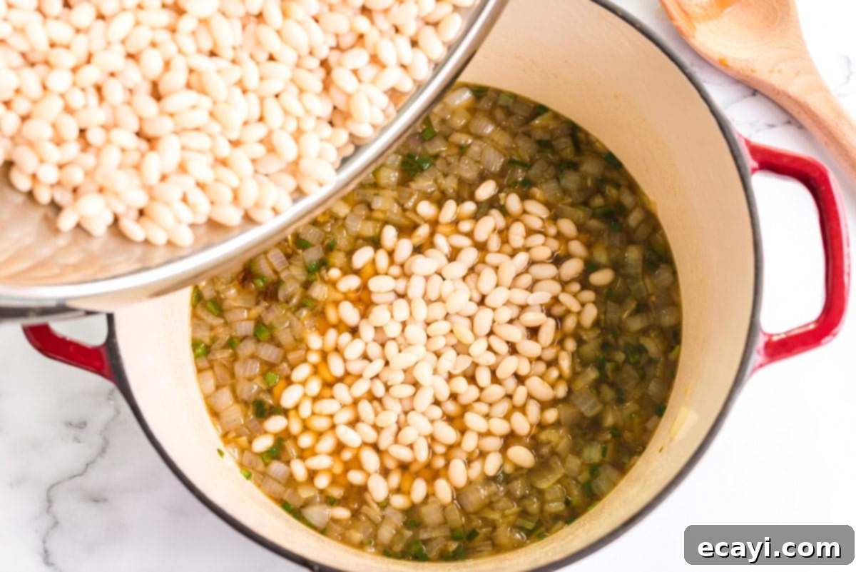 Grandma's Classic Baked Beans 8 adding beans to onion mixture in pan