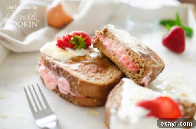 This French toast is stuffed with sweet strawberries and cream filling. Turn your usual breakfast into something amazing - Strawberry Stuffed French Toast! A perfectly cooked piece of French toast, cut open to reveal the strawberry and cream filling