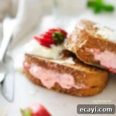 Decadent Strawberry Cream Stuffed French Toast 2 A close up of a strawberry cream french toast on a plate