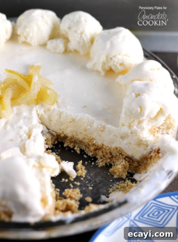 Lemon Icebox Dream Pie 5 A slice of frozen lemonade pie removed, showing its layers of creamy filling and sturdy crust.