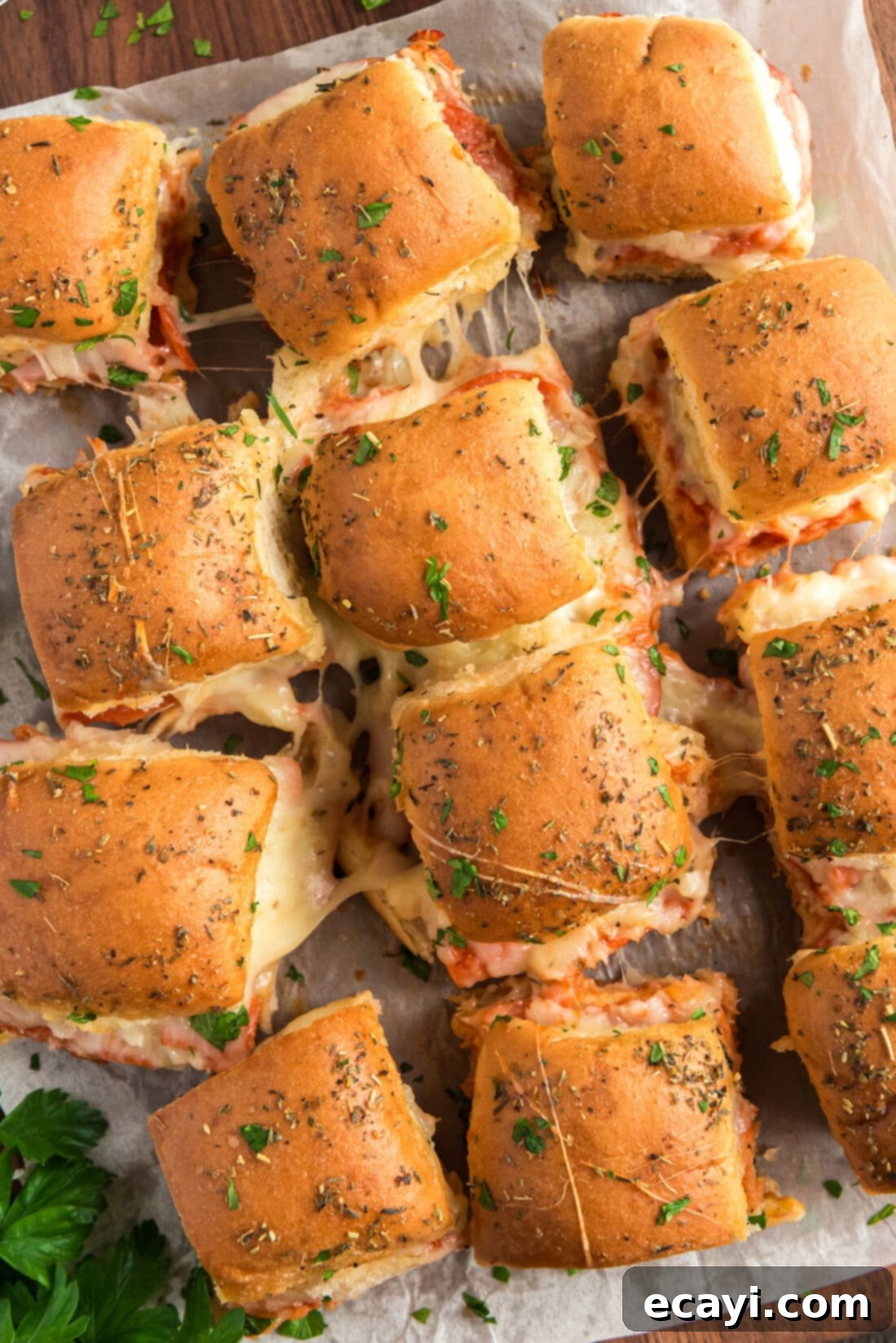 Cheesy Pizza Bites 13 An overhead shot of an entire pan of baked pizza sliders, garnished with fresh herbs