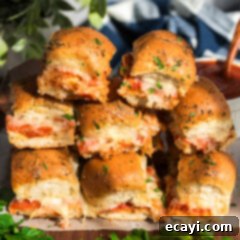 Cheesy Pizza Bites 14 Pizza Sliders stacked on top of each other, showcasing their cheesy, golden appeal