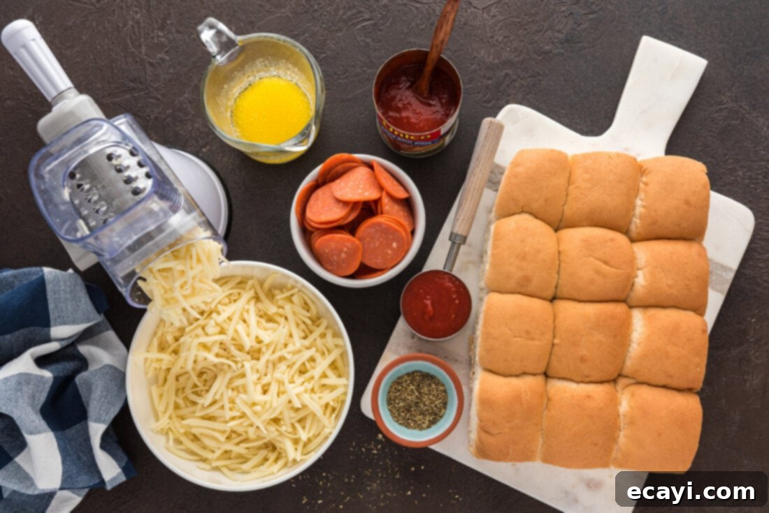 Cheesy Pizza Bites 4 A flat lay of fresh ingredients for pizza sliders, including buns, cheese, pepperoni, and sauce