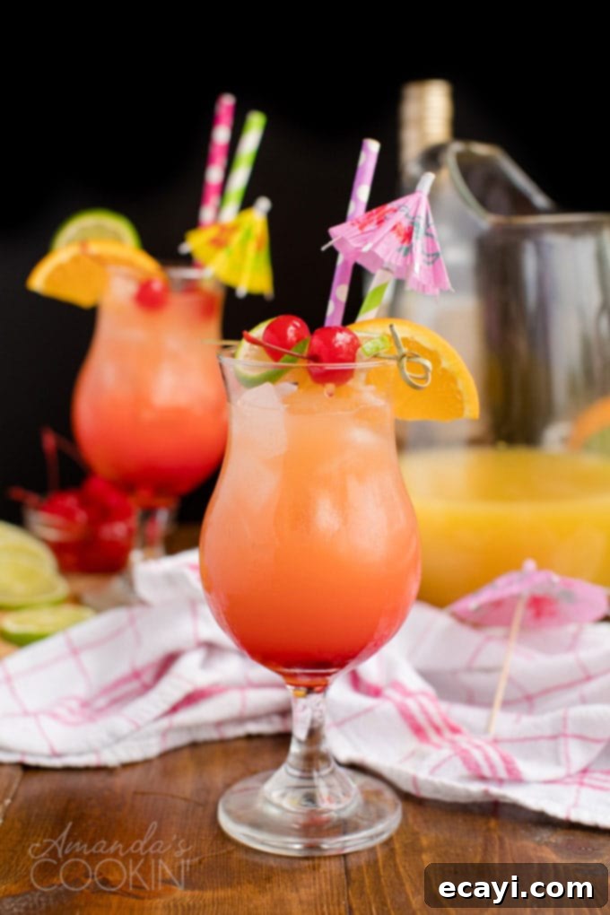 Punch of Paradise 11 Two glasses of rum punch with tropical garnishes set against a sleek black background