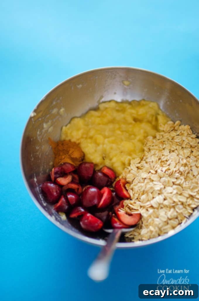Cherry Cheesecake Power Pops 4 A stainless steel bowl filled with mashed bananas, chopped cherries and rolled oats.