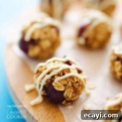 Cherry Cheesecake Power Pops 7 A close up photo of cherry cheesecake energy balls drizzled with cream cheese frosting.