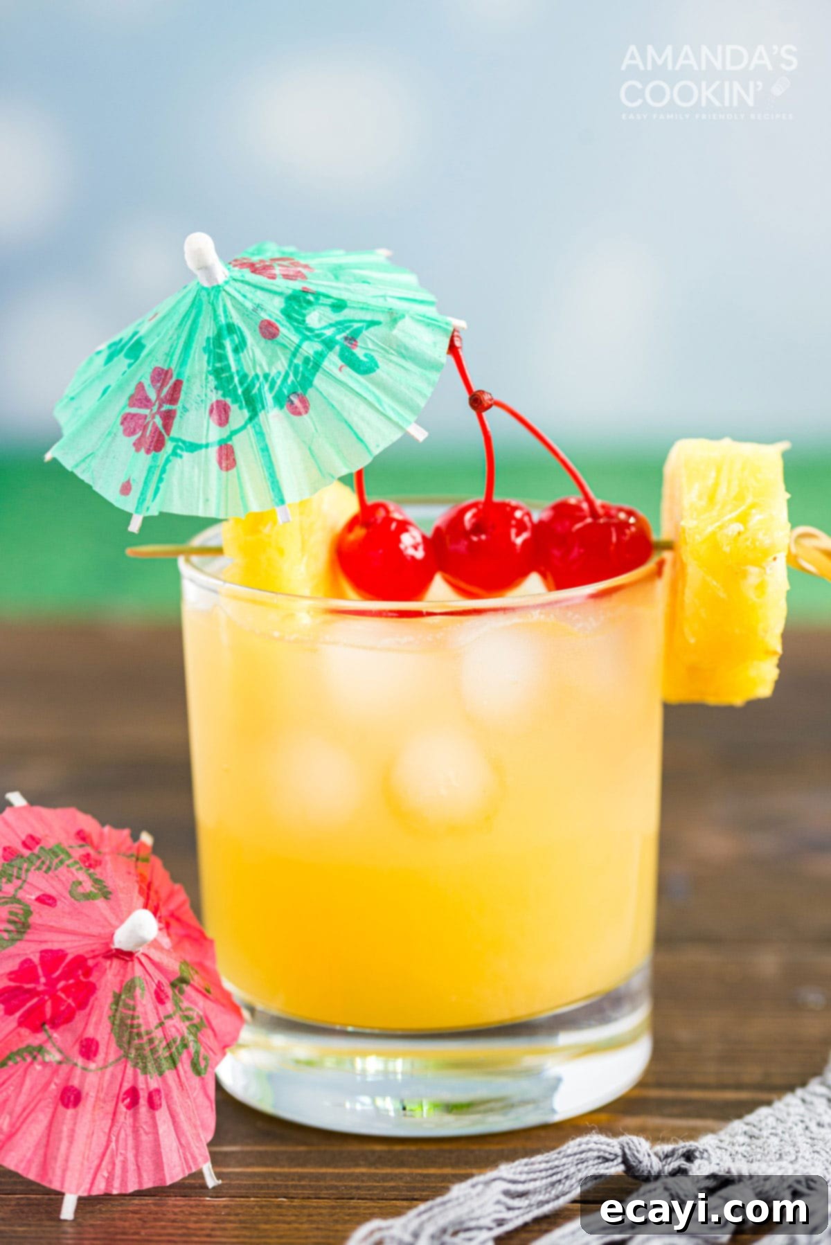 A basic Mai Tai is easy to make. This rum cocktail has combines almond, lime, and tropical fruit flavors. Great for summer and reminds you of the beach! A perfectly prepared Mai Tai cocktail, served in a rocks glass with a cocktail umbrella and cherry garnish, ready to be enjoyed.