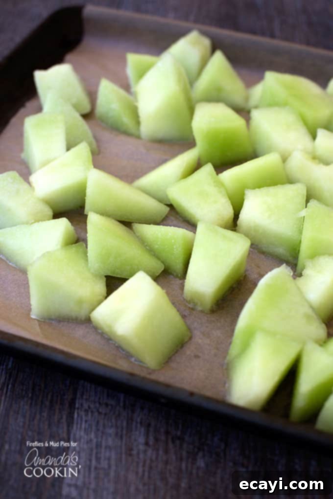 Zesty Honeydew Chill 4 A vibrant close-up of freshly chopped honeydew melon cubes, ready for freezing and blending into a refreshing summer drink.