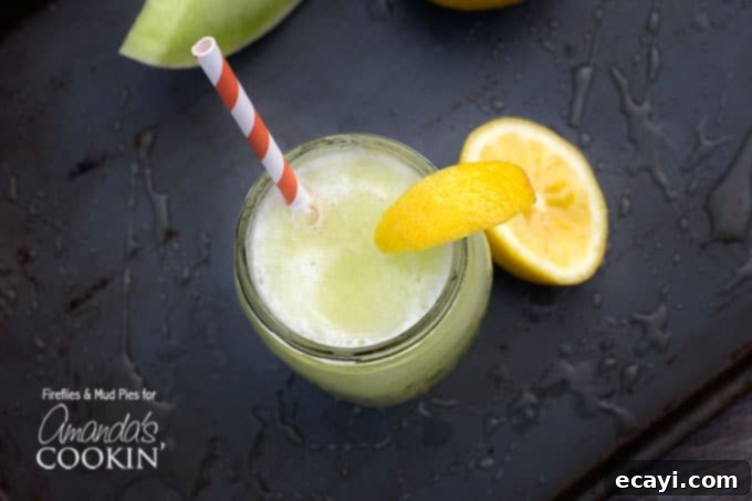 Zesty Honeydew Chill 5 An inviting overhead view of a mason jar filled with a vibrant honeydew lemon slush, topped with a bright lemon wedge and paired with a cheerful red and white striped straw. A true taste of summer.