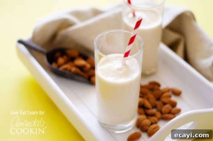 Velvety Almond Maple Delight 4 An almond maple smoothie resting on a white plate with scattered almonds.
