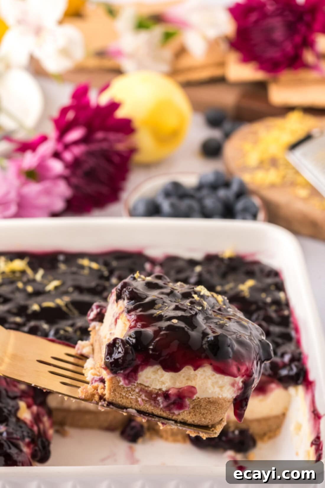 Creamy No-Bake Blueberry Cheesecake 2 Spatula lifting up a slice of No Bake Blueberry Cheesecake, showcasing its beautiful layers.