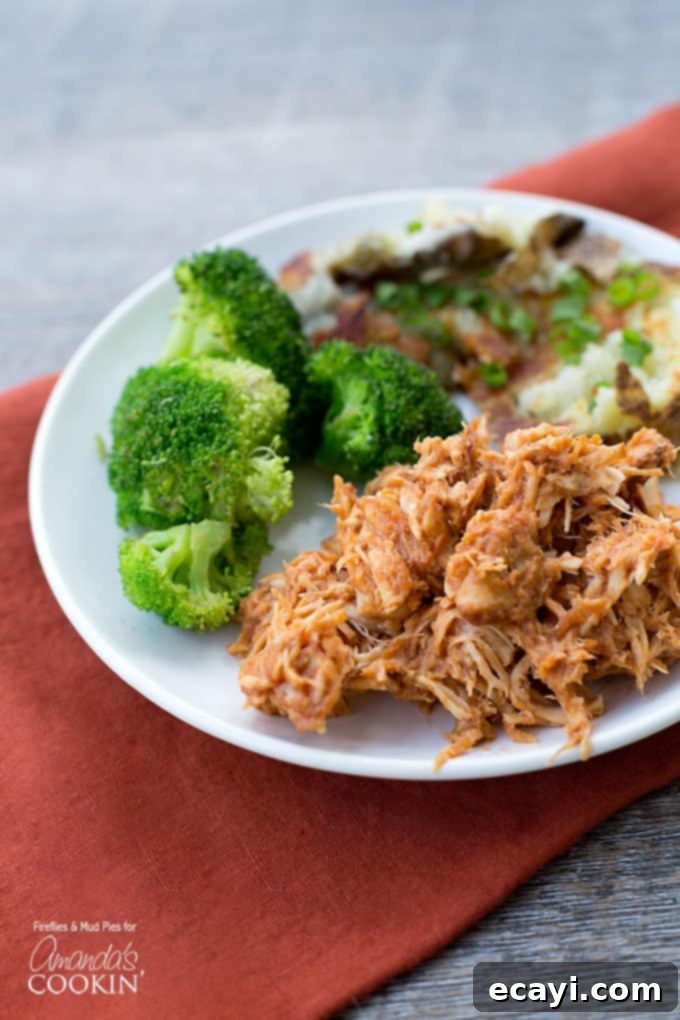 Effortless Slow Cooker BBQ Chicken 2 A close up photo of a plate of BBQ crockpot chicken and steamed broccoli.