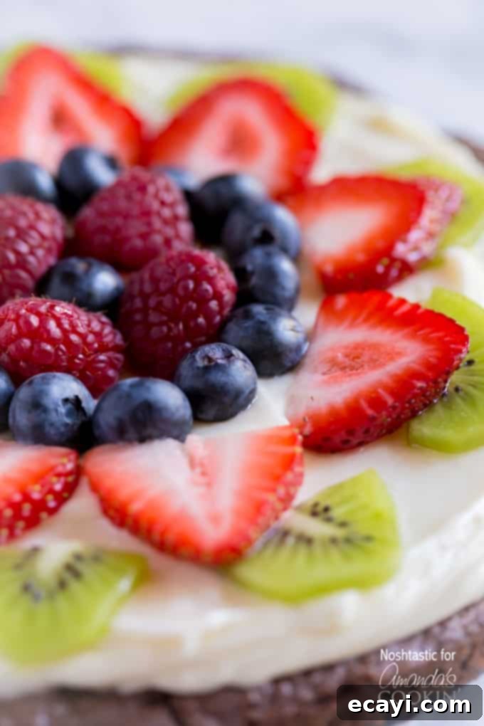 Effortless Fruit Tart 2 A close up of cut up strawberries, kiwi, blueberries and raspberries on a brownie pizza.