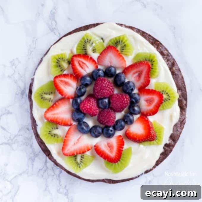 Effortless Fruit Tart 3 An overhead of cut up fruit on top of a brownie pizza.
