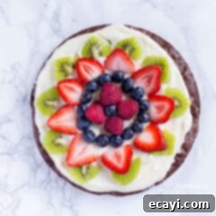 Effortless Fruit Tart 6 An overhead photo of fruit cut up on top of a brownie pizza.