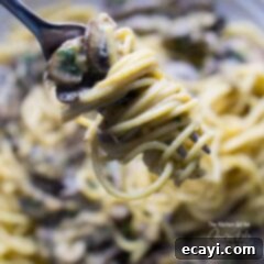 One-Pan Mushroom Stroganoff 6 A close up of creamy mushroom stroganoff swirled onto a fork, garnished with fresh parsley.