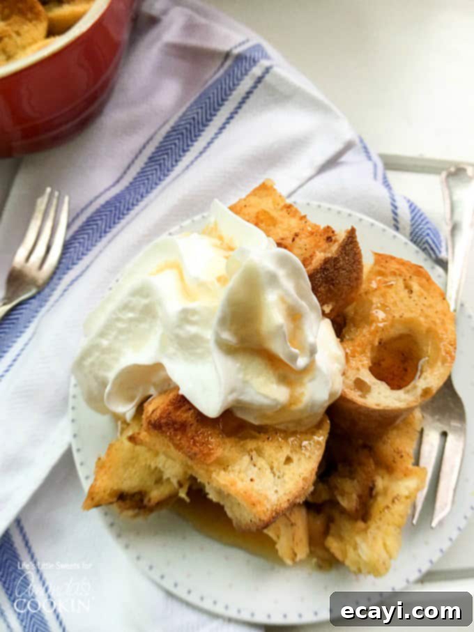 Overnight French Toast Bake 6 A close up of french toast casserole topped with vanilla whipped cream.