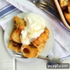Overnight French Toast Bake 8 An overhead of french toast casserole on a white plate topped with vanilla whipped cream.
