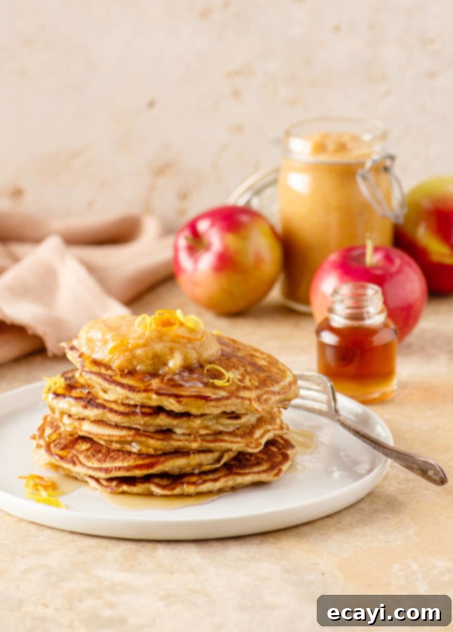 Whole Wheat Apple Pancakes with Zesty Citrus Applesauce 2 Stack of fluffy whole wheat apple pancakes drizzled with maple syrup and served with baked citrus applesauce