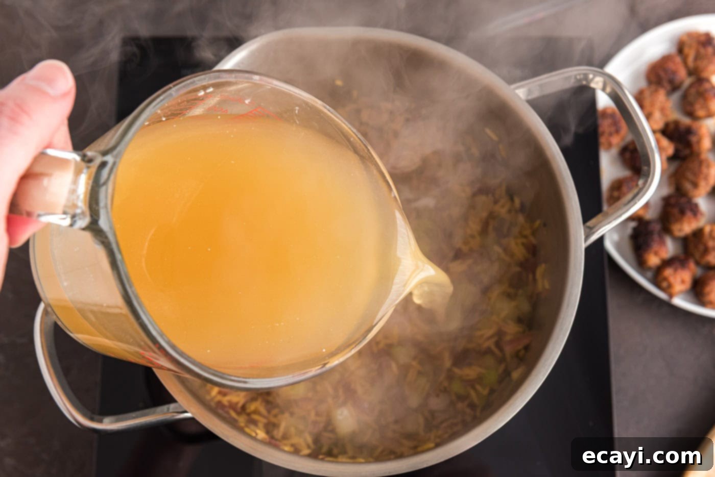 Hearty Sausage Orzo Soup 8 pouring chicken broth into stock pot