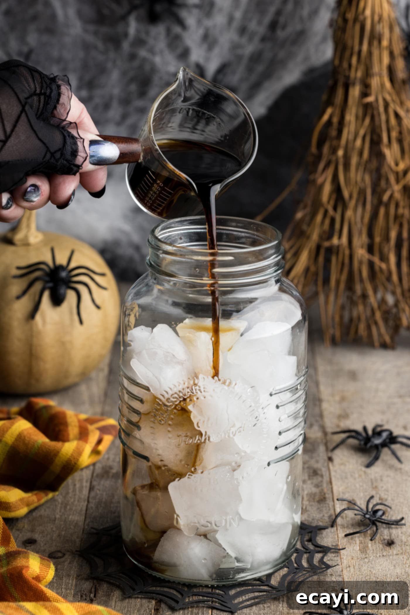 Cobweb Elixir 5 Pouring Kahlua into a cocktail shaker with ice