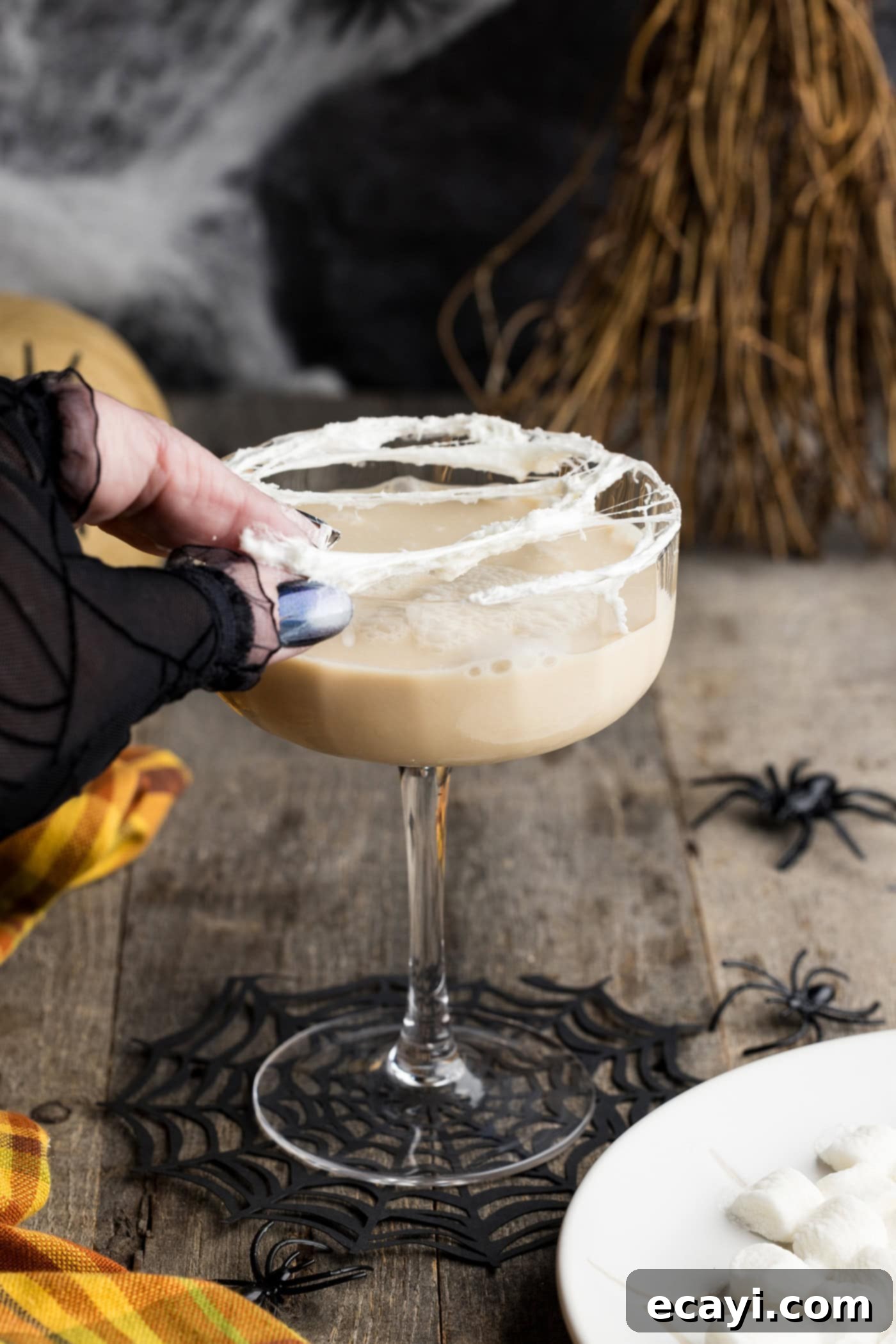 Cobweb Elixir 8 hand stretching melted marshmallow over cocktail glass rim