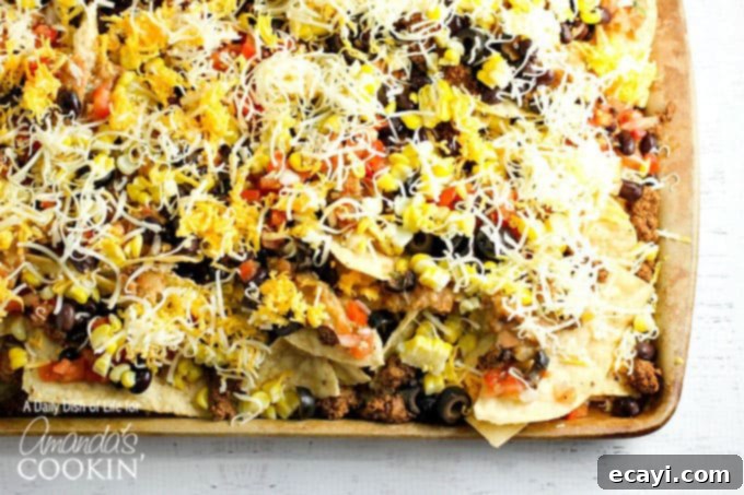 Ultimate Nacho Feast 5 A close up overhead  of loaded nachos on a baking sheet.