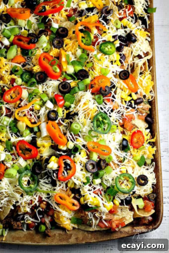 Ultimate Nacho Feast 7 An overhead of loaded nachos on a baking sheet.