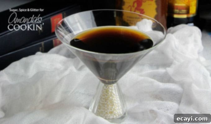 Nevermore Coffee Cocktail 4 A clear martini glass filled with a raven coffee cocktail, with a feather garnish.