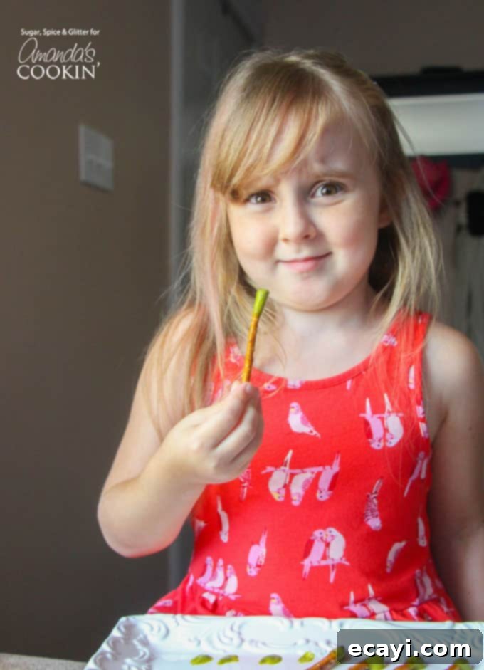 Picky Pops 3 A little girl holding a booger on a stick, showcasing the fun and gross nature of the Halloween party treat.