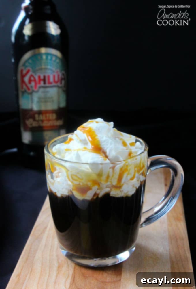 Salted Caramel Coffee Elixir 2 A salted caramel coffee cocktail in a clear mug with whipped cream and drizzled caramel on top.