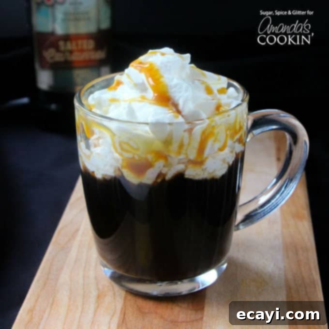 Salted Caramel Coffee Elixir 3 A salted caramel coffee cocktail in a clear mug with whipped cream and drizzled caramel on top.