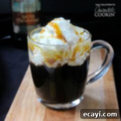 Salted Caramel Coffee Elixir 4 A salted caramel coffee cocktail in a clear mug with whipped cream and drizzled caramel on top.