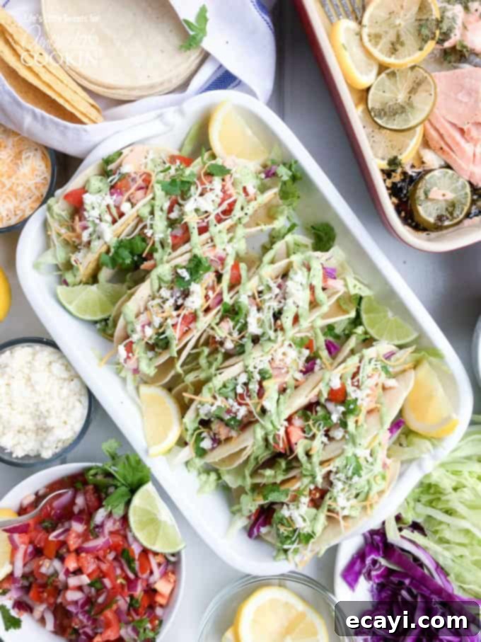 Zesty Salmon Street Tacos 2 An overhead photo of vibrant salmon tacos artfully arranged in a casserole dish, accompanied by fresh lemon and lime wedges, ready to be served.