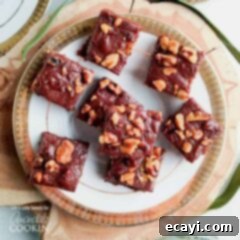 Decadent Walnut Chocolate Fudge 7 An overhead of chocolate walnut fudge squares on a white and gold plate.