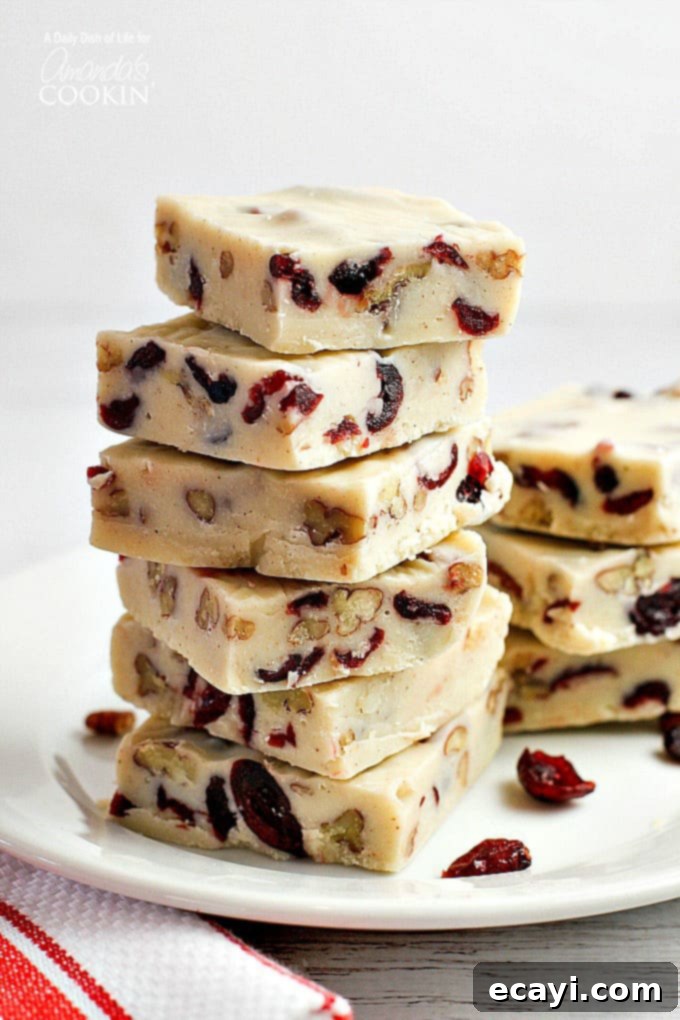 Blissful White Chocolate Cranberry Fudge 2 Squares of white chocolate cranberry fudge stacked on top of each other, ready to be enjoyed.