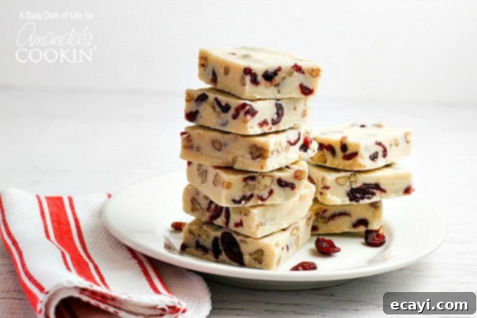 Blissful White Chocolate Cranberry Fudge 4 Close-up shot of a square of WHITE CHOCOLATE CRANBERRY FUDGE, highlighting its texture and festive appeal.