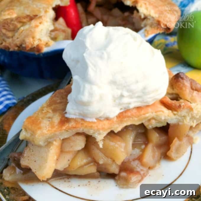 Rustic Apple Pie Perfection 7 A close-up of a large slice of delicious homemade apple pie, showing the golden-brown crust and juicy apple filling, sitting on a white plate with a fork.