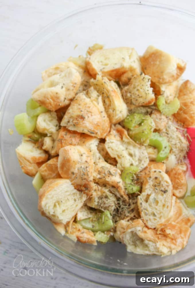 Golden Fan-Cut Potatoes 12 Croissant stuffing step 2: Diced croissants mixed with sautéed celery and onions in a large bowl, ready for seasoning and liquids.