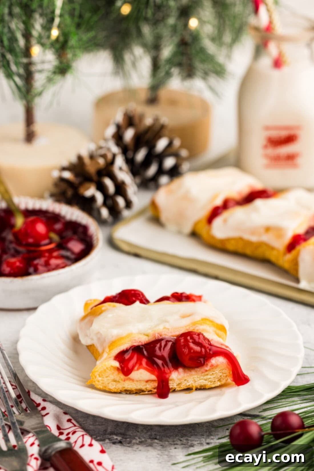 Peppermint Swirl Danish 12 A perfectly portioned slice of Candy Cane Danish on a white plate, showcasing the distinct layers of flaky crescent dough, creamy cheese, and vibrant cherry filling