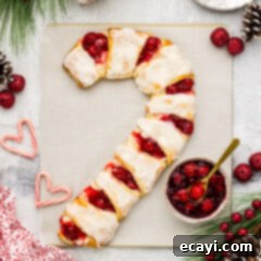 Peppermint Swirl Danish 13 Close up photo of a freshly baked Candy Cane Danish, golden brown with white glaze, resting on parchment paper after baking