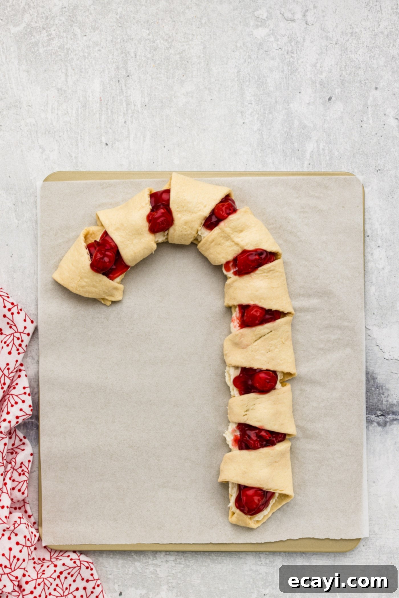 Peppermint Swirl Danish 9 The pointed tips of crescent rolls folded over to create a striped pattern on the cherry cream cheese candy cane danish, beautifully assembled and ready for the oven