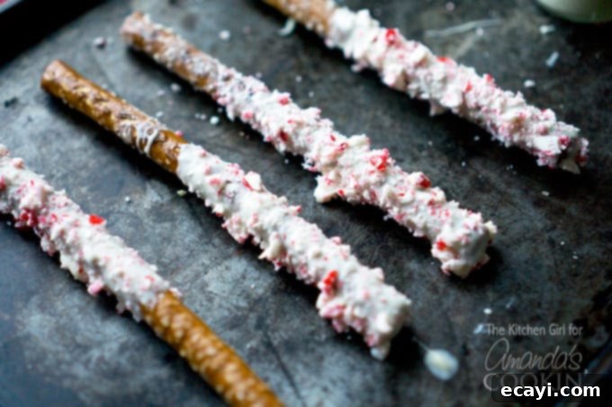 Holiday Minty Pretzel Crunch 4 A close up photo of four white chocolate candy cane pretzel sticks.