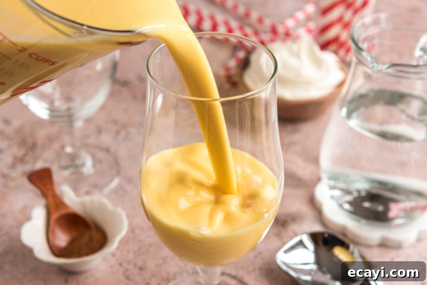 Creamy Eggnog Delight 5 Pouring rich eggnog into a tall glass, filling it halfway