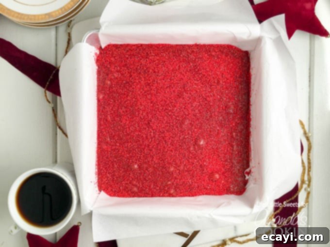 Decadent Red Velvet Fudge 4 Red velvet fudge setting beautifully in an 8x8 inch square baking pan, showcasing its rich color before being cut.