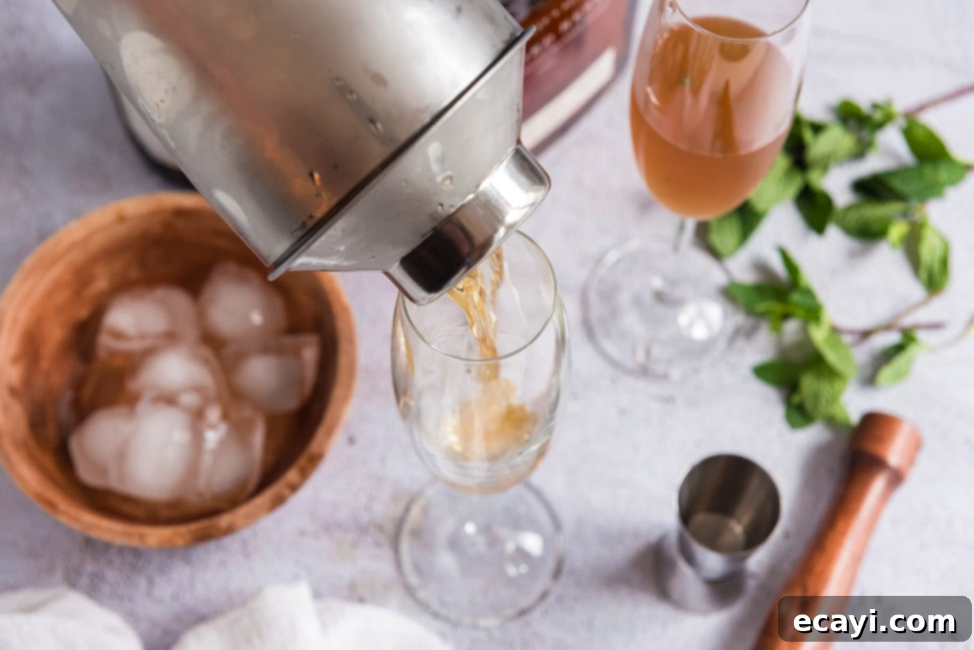 Minty Sparkle 8 pouring mint julep into champagne glass