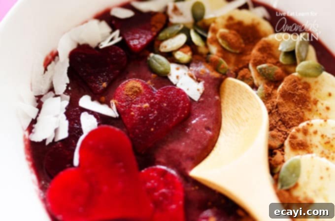 Decadent Red Velvet Smoothie Bowls 4 A close up of a wooden spoon in a bowl of red velvet smoothie.